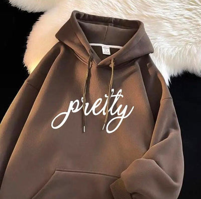 Brown hoodie with 'pretty' text on a textured white background